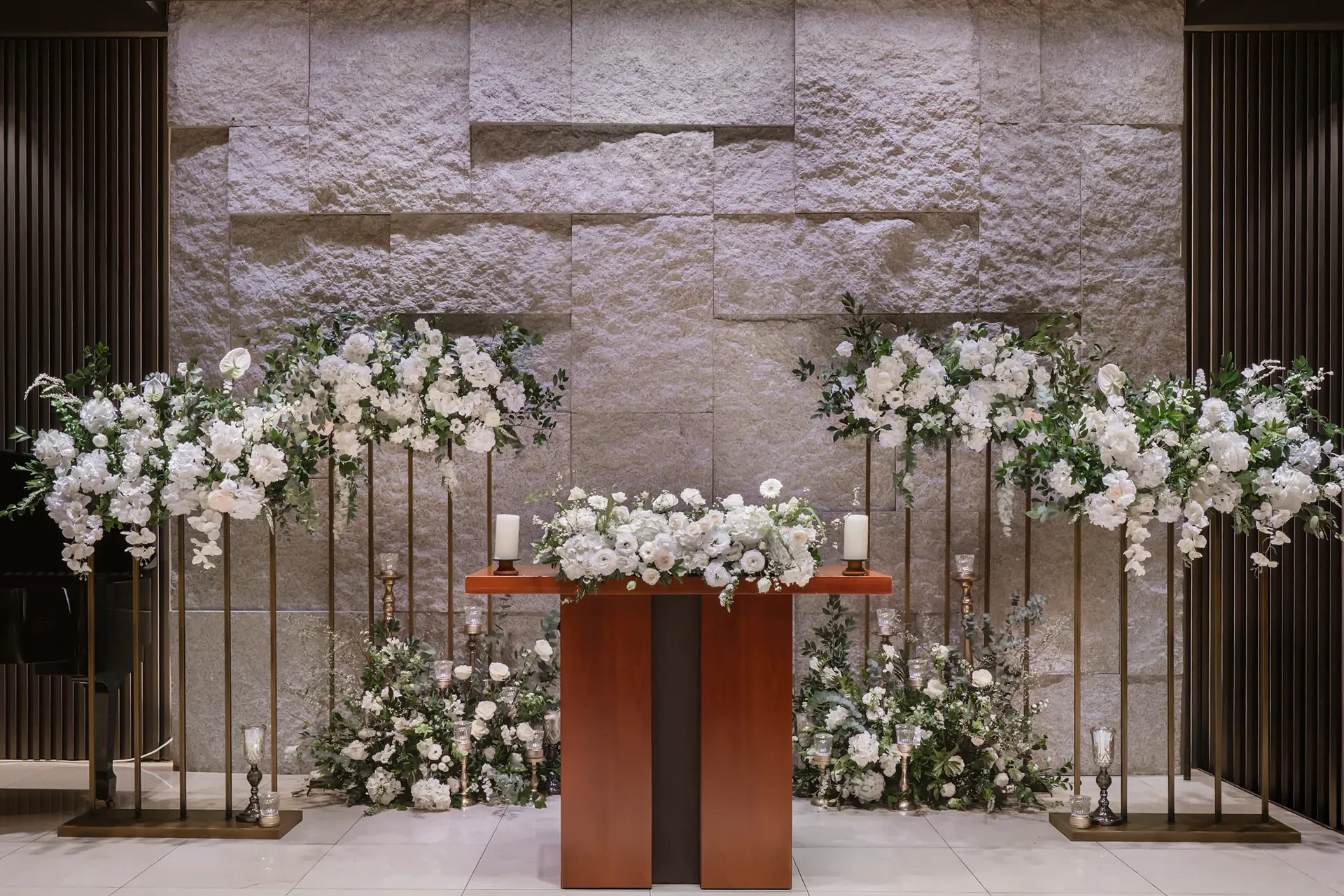 석재 벽과 화이트 플라워로 장식된 아벤티움 예식 공간